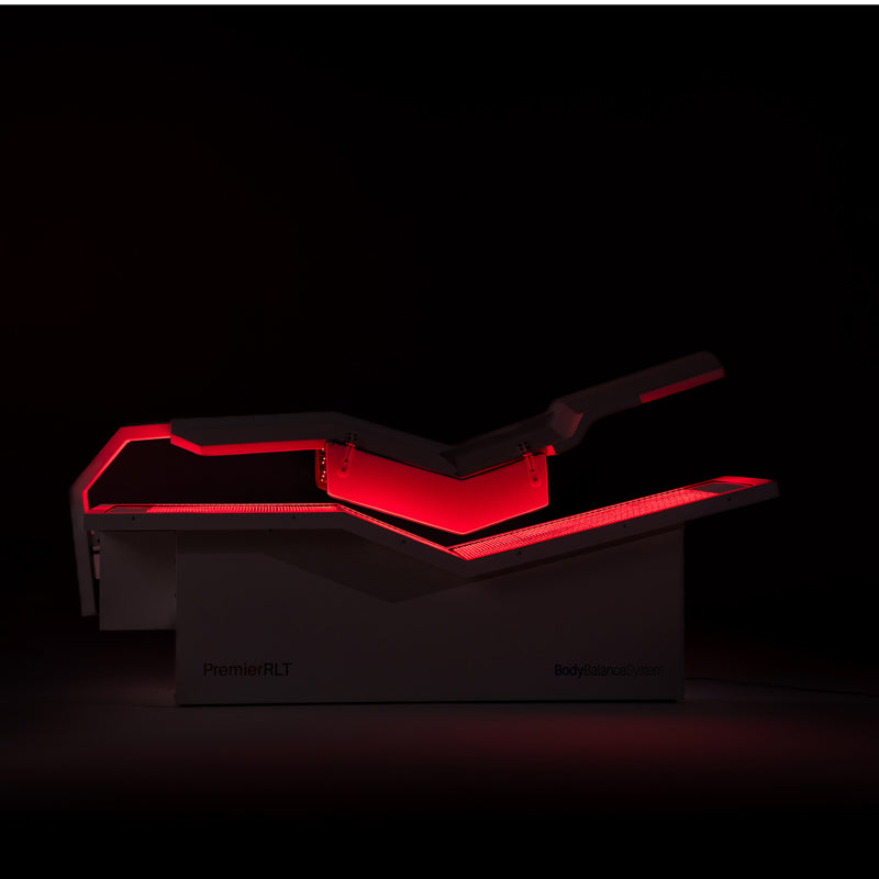 Body Balance System PremierRLT red light therapy bed with canopy closed and LEDs glowing on a dark background