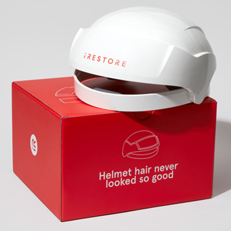 iRestore Essential Laser Hair Growth System helmet placed on red manufacturer box
