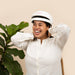 Female model wearing iRestore Essential Laser Hair Growth System helmet, smiling during at-home red light therapy session
