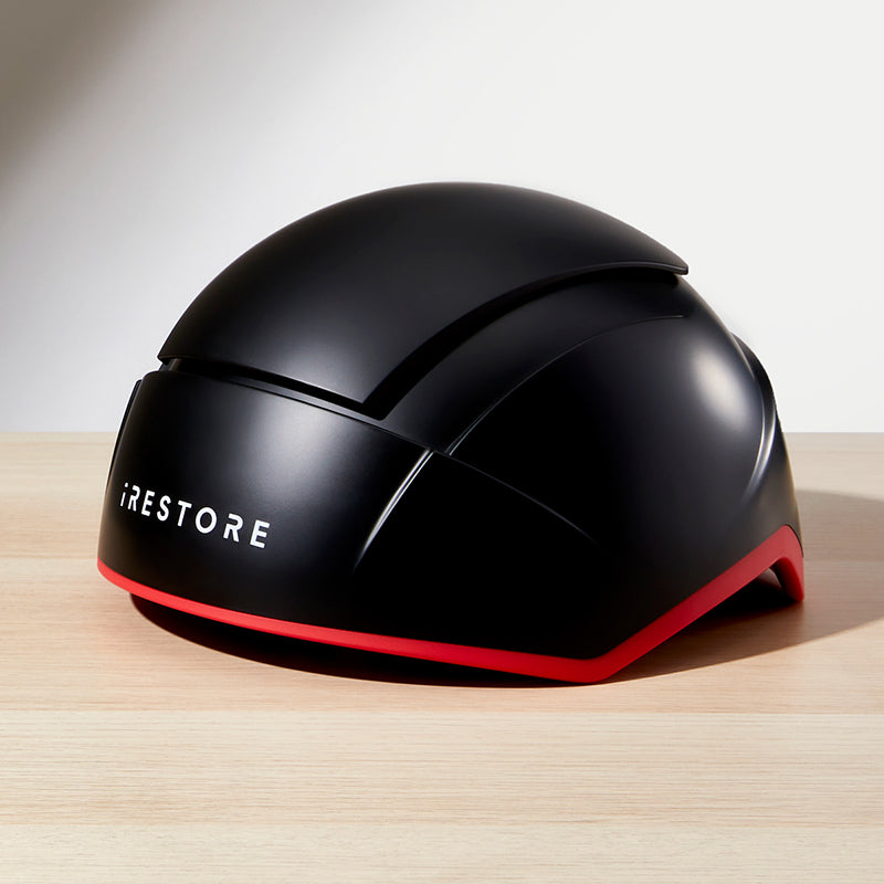 iRestore Elite black laser hair growth helmet displayed on countertop with white background
