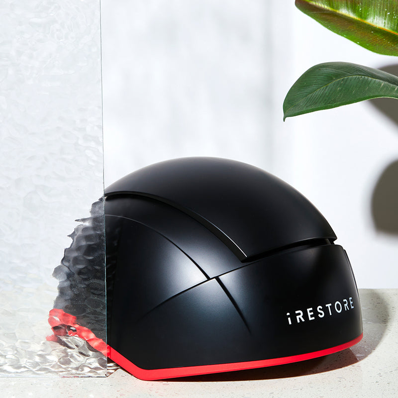 iRestore Elite black laser hair growth helmet displayed on countertop with white background
