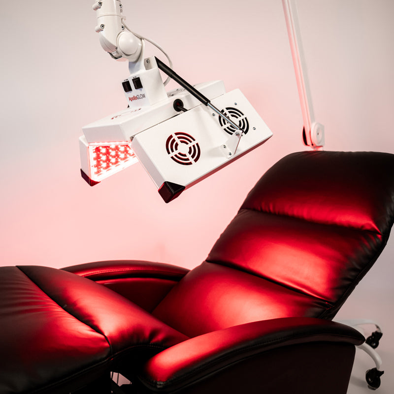 ApolloGlow red light therapy system positioned over reclining chair for full-body treatment