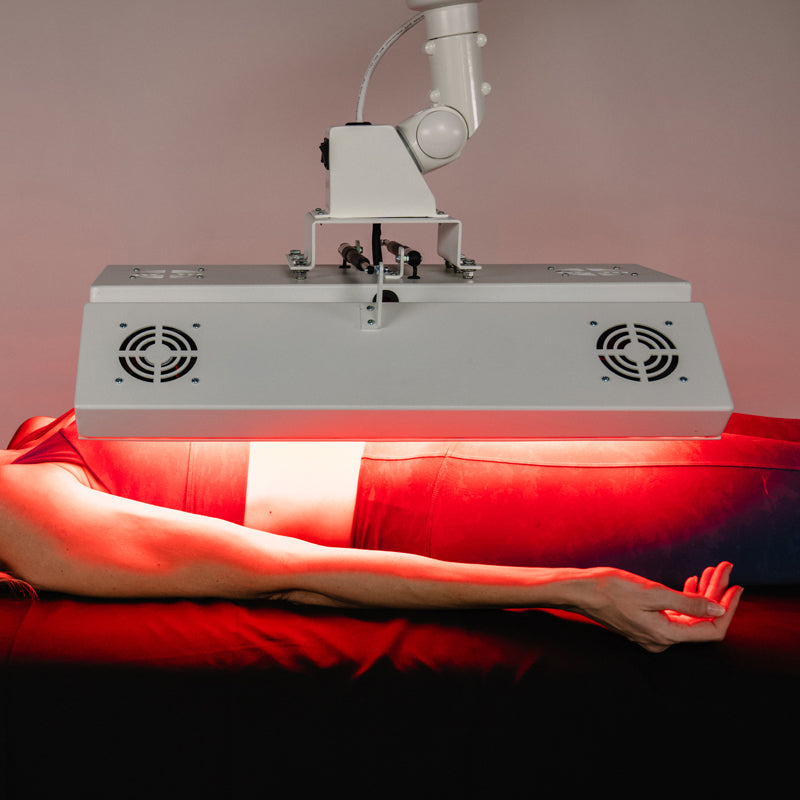 Female model receiving upper body treatment under the Body Balance System ApolloARC red light therapy panel