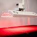 Close-up of the Body Balance System ApolloARC red light therapy panel showing LEDs while positioned over a treatment table