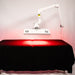 Body Balance System ApolloARC red light therapy panel in lowered position over a treatment table on adjustable arm
