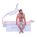 Body Balance System OvationULT Red Light Therapy Bed – front view with lights on, male model seated in center, facing forward, demonstrating full-body infrared treatment session.