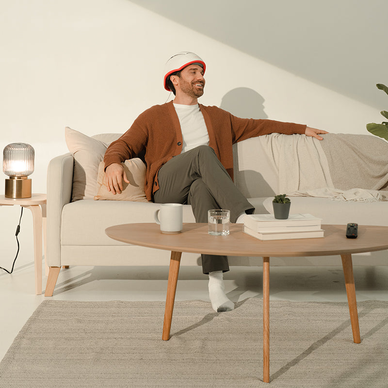 Male receiving treatment from the iRestore  Professional laser hair growth helmet in the comfort of his own home on the couch.