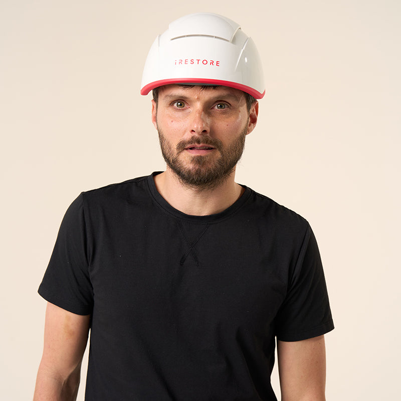 male model posing with the iRestore Professional laser hair growth helmet